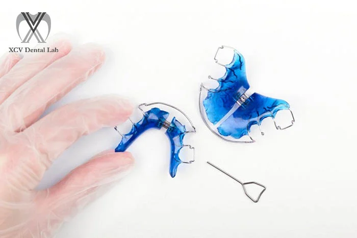 Orthodontic retainer – traditional Hawley retainer with acrylic base and metal wire across the front teeth.
